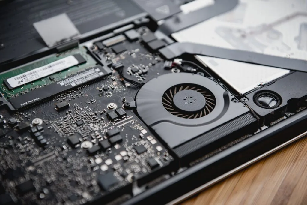 ITFIX2U | Detailed view of a laptop's internal circuitry and cooling fan showcasing technology and engineering.